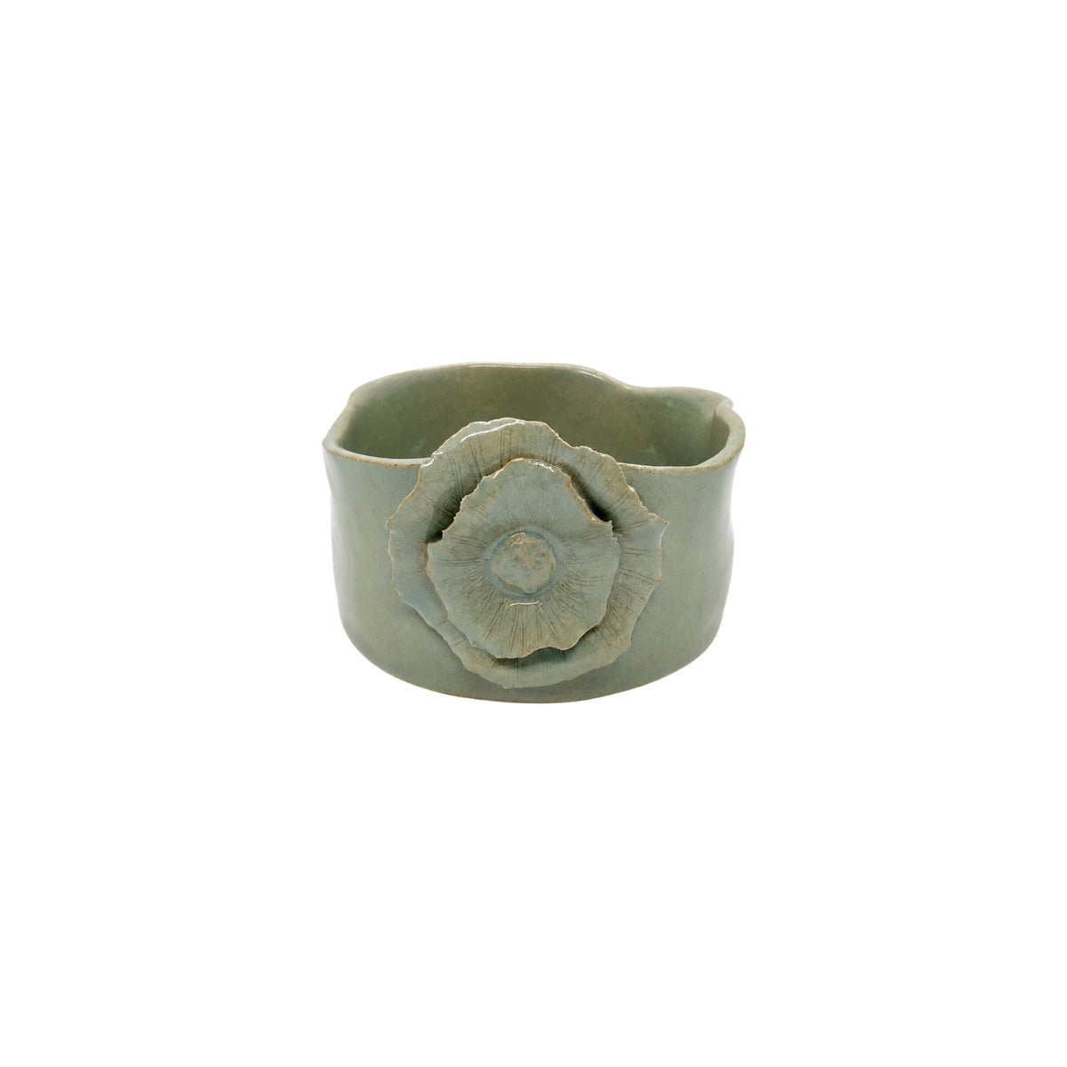 Front view of old green wavy round ceramic bowl by Nayla's Ceramics showing layered flower blossom design