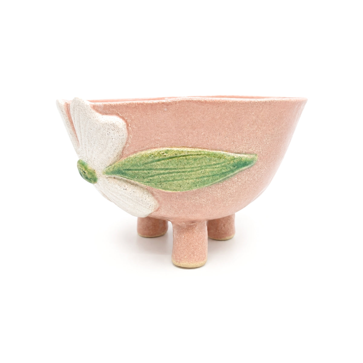 Side view of Nayla's Ceramics tripod footed blush pink bowl highlighting green leaf glaze accent and natural pottery texture