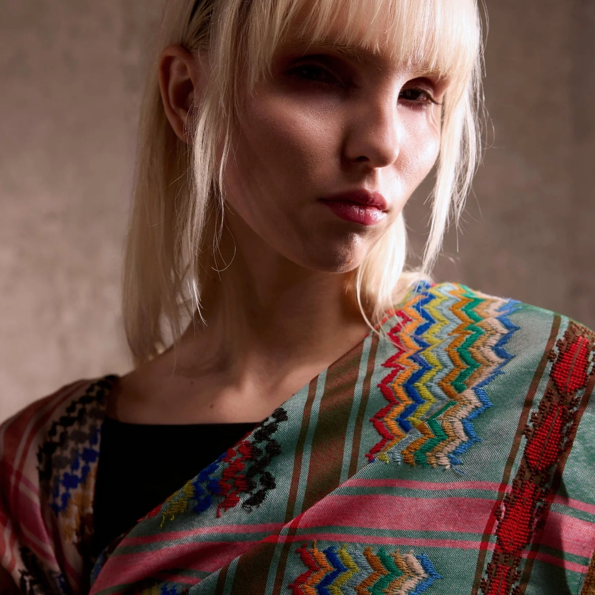 Close up view of SEP mini green multicolor keffiyeh scarf showcasing hand-stitched details and vibrant chevron embroidery