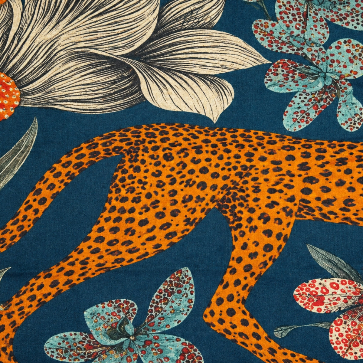 Close-up of the scarf's cheetah motif, showing the spotted coat against green leaves and teal accents