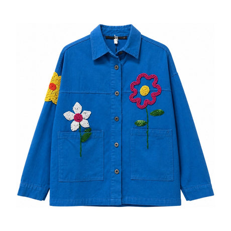 Flat lay of a blue button front jacket with hand beaded flowers on the chest and sleeve, twin patch pockets, collared neckline, and long sleeves, showcasing detailed beadwork craftsmanship
