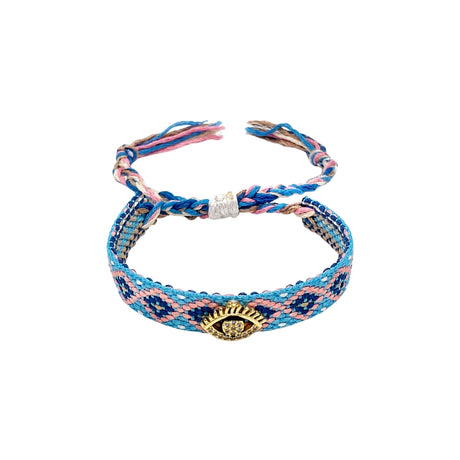 Woven friendship bracelet in blue pink and navy geometric pattern with gold evil eye charm and crystal detail, adjustable pull cord closure