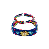 Woven friendship bracelet in navy pink and multicolor geometric pattern with gold sunburst evil eye charm, adjustable pull cord closure