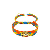 Woven friendship bracelet in orange yellow and blue zigzag pattern with gold sunburst evil eye charm, adjustable pull cord closure