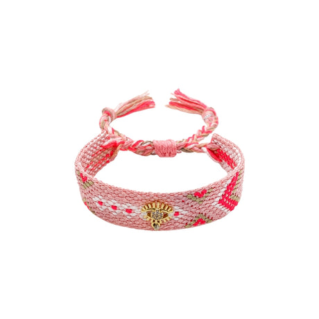 Woven friendship bracelet in pink white and deep pink pattern with gold evil eye charm and crystal detail, adjustable pull cord closure
