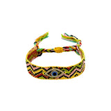 Woven friendship bracelet in yellow black and multicolor zigzag pattern with blue enamel evil eye charm and crystal detail, adjustable pull cord closure