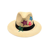 Three-quarter angled view of the City Girl hand-painted colored stars wide brim straw sun hat, highlighting the scattered star motif wrapping around the crown and the wide shading brim