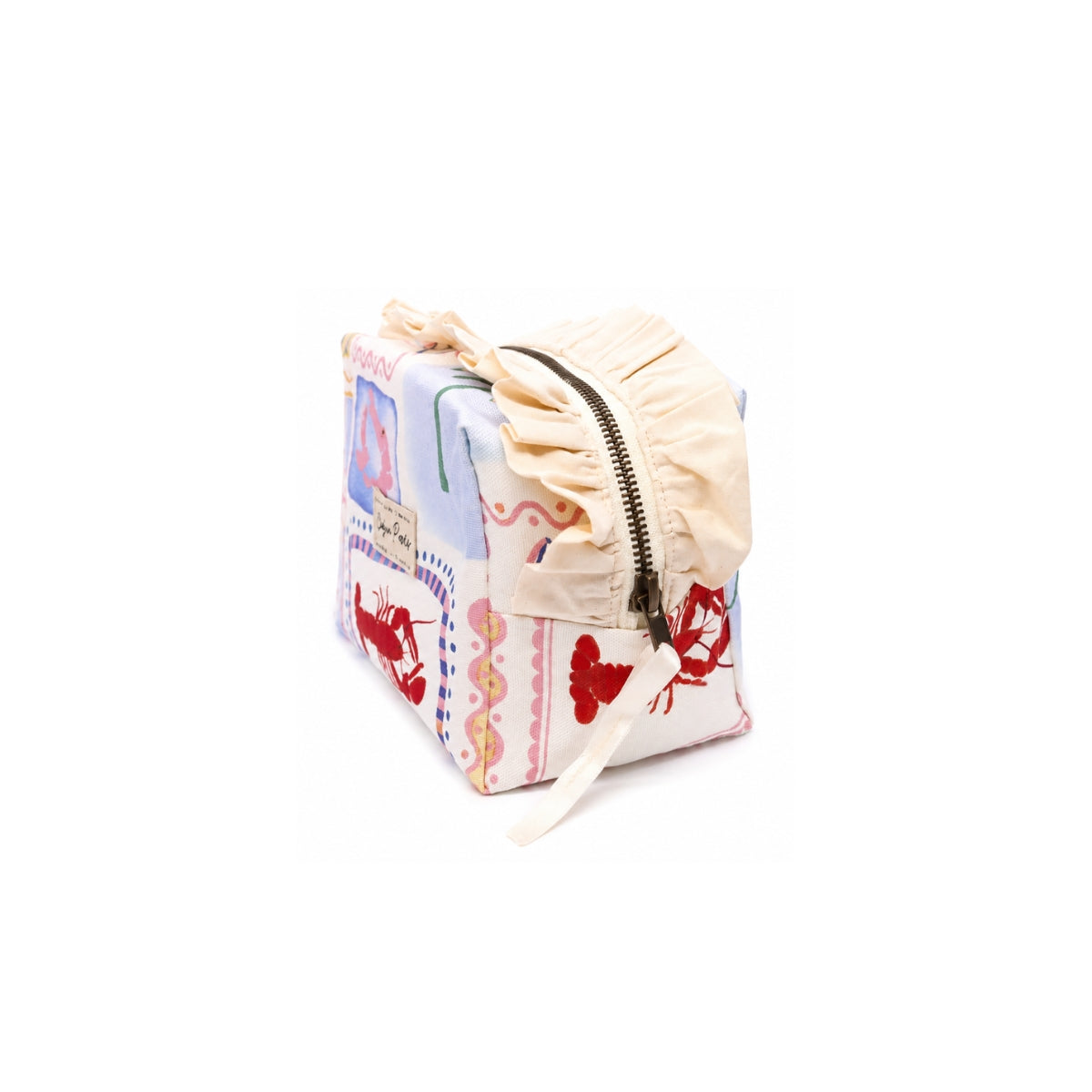 Side angle view of the Medium Paola Riviera toiletry bag showing the cream ruffle border and antique brass top zipper closure.