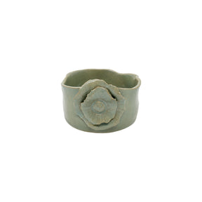 Front view of old green wavy round ceramic bowl by Nayla's Ceramics showing layered flower blossom design