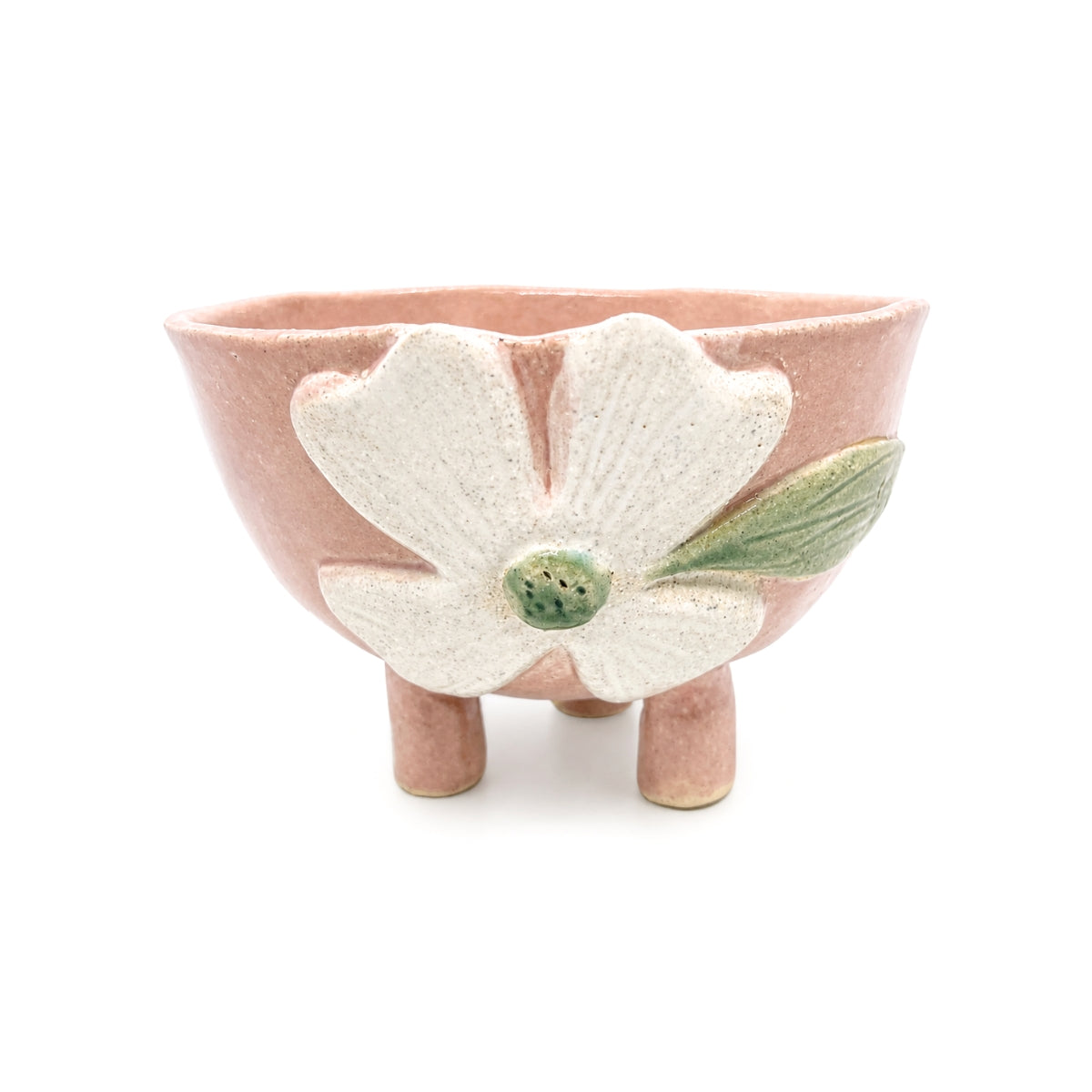 Front view of handcrafted footed pink clover ceramic bowl with legs by Nayla's Ceramics featuring a raised off-white flower and green center