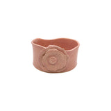 Front view of Nayla's Ceramics pink wavy round ceramic bowl featuring a sculpted flower emblem