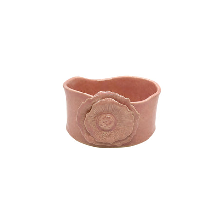 Front view of Nayla's Ceramics pink wavy round ceramic bowl featuring a sculpted flower emblem