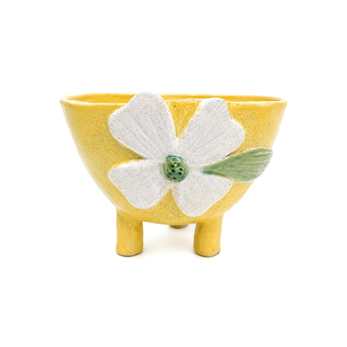 Front view of handcrafted footed yellow clover ceramic bowl with legs by Nayla's Ceramics featuring a raised off-white flower and green center