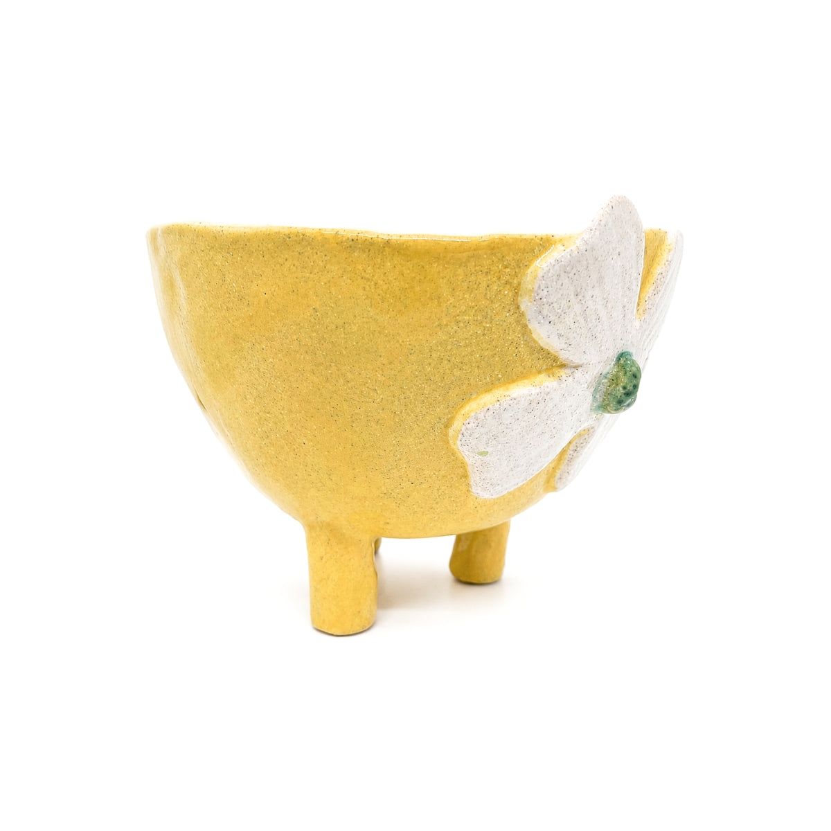 Side angle view of Nayla's Ceramics footed yellow ceramic bowl showing tripod legs and raised flower petal detail