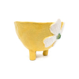Side angle view of Nayla's Ceramics footed yellow ceramic bowl showing tripod legs and raised flower petal detail