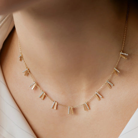 Model wearing Orchid Jewelry 18k gold and diamond tilted cascade choker necklace styled along the neckline
