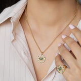 Model wearing Orchid Jewelry 18k gold emerald and diamond O'hara pendant necklace along the neckline