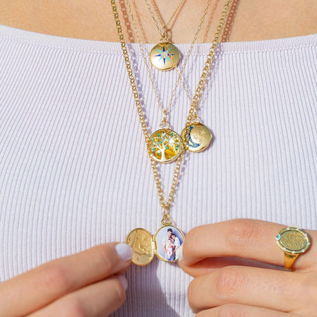 Model wearing Orchid Jewelry 18k yellow gold Moonlight locket necklace styled along the neckline
