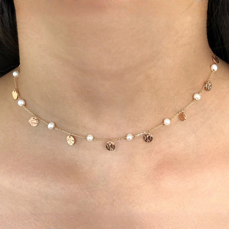 Model wearing Orchid Jewelry 18k gold pearl and hammered coin disc fiesta choker along the neckline