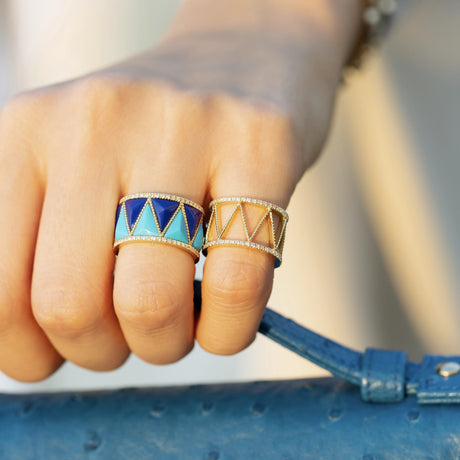 Close-up of model wearing Orchid Jewelry 18k gold Soho Buz diamond ring paired with a blue enamel statement ring