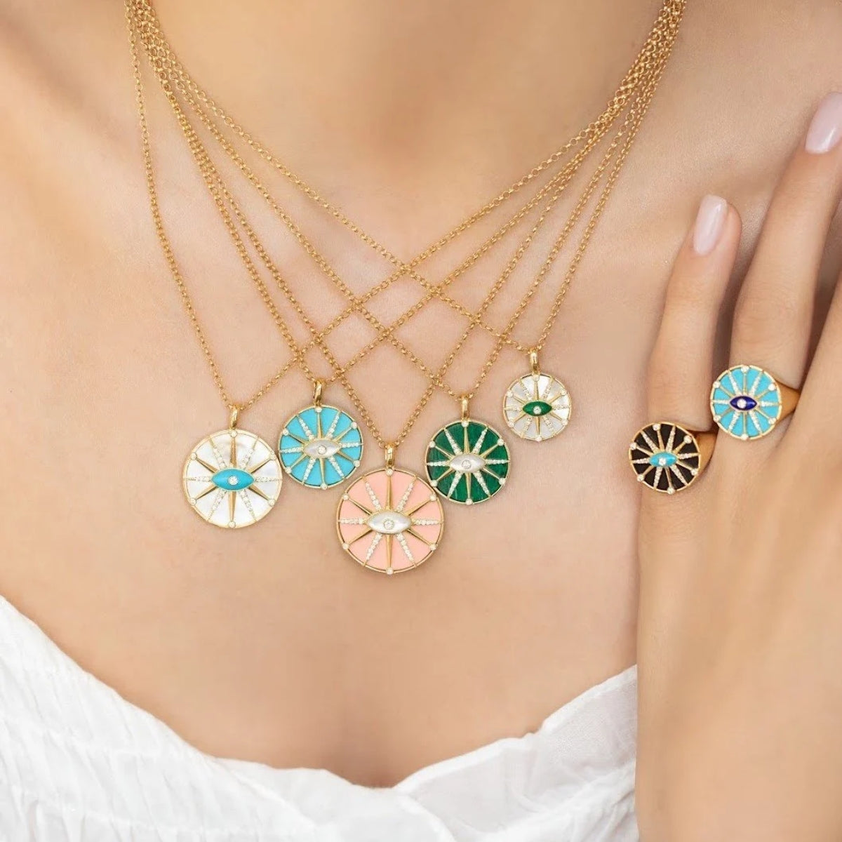 Model wearing the Orchid Jewelry 18k gold O'Hara Eye turquoise ring on finger alongside layered matching eye pendant necklaces