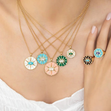 Model wearing the Orchid Jewelry 18k gold O'Hara Eye turquoise ring on finger alongside layered matching eye pendant necklaces