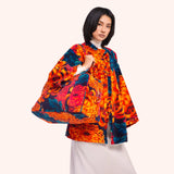 Model carrying the chrysanthemum print velvet weekend bag by hand, wearing the matching chrysanthemum velvet jacket