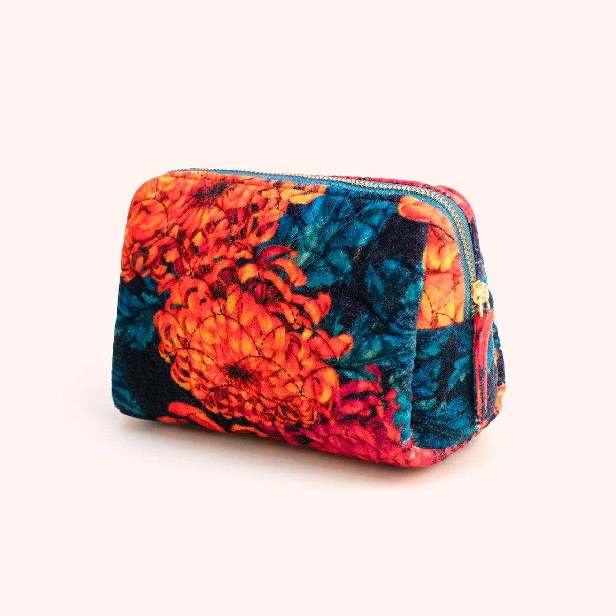 Orange and teal chrysanthemum print quilted velvet vanity bag with coral zip pull, shown at an angle