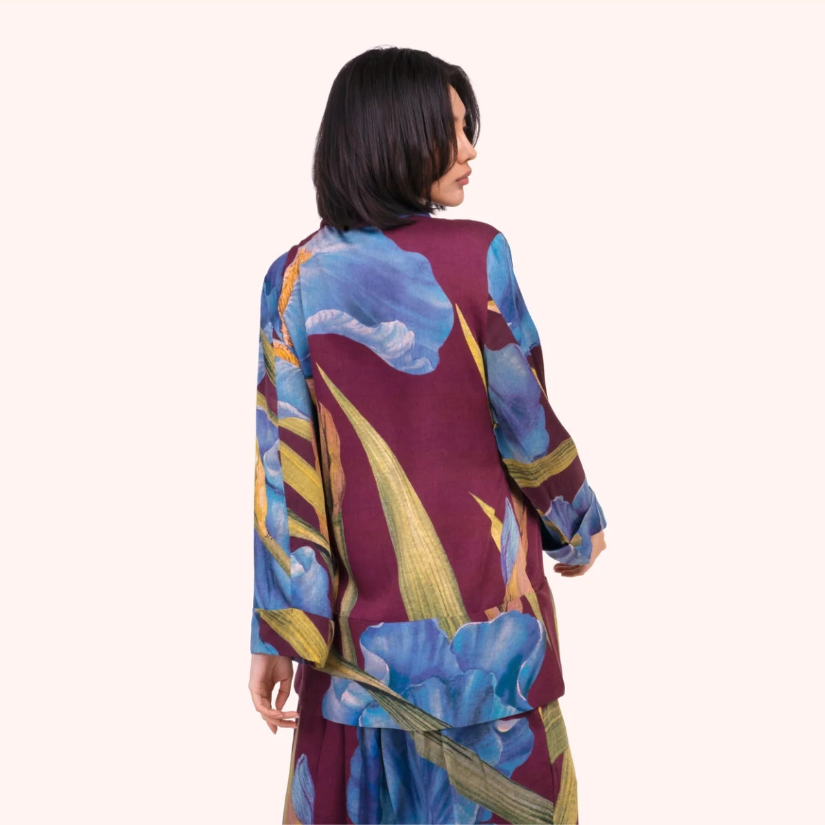 Back view of the plum iris print jacket, showing the full scale floral pattern across the shoulders and sleeves