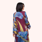 Back view of the plum iris print jacket, showing the full scale floral pattern across the shoulders and sleeves