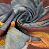 Close-up of the iris wool mix scarf fabric, showing the brown, teal, and mustard print and soft woven texture