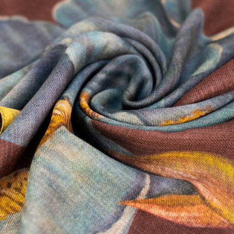 Close-up of the iris wool mix scarf fabric, showing the brown, teal, and mustard print and soft woven texture