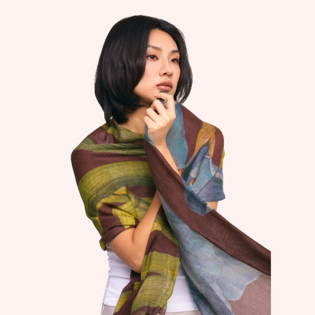 Model wearing the brown, olive, and blue iris print wool mix scarf draped around the shoulders and neck