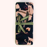 Plum and navy orchid print velvet jewelry roll tied closed with a moss green ribbon
