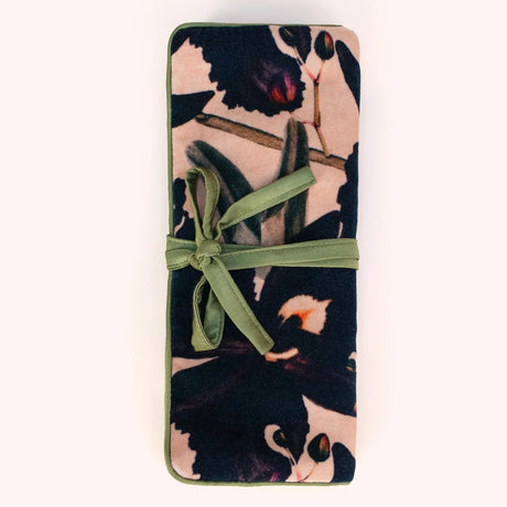 Plum and navy orchid print velvet jewelry roll tied closed with a moss green ribbon