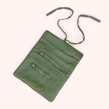 Interior view of the midnight orchid jewelry roll unrolled, showing ring holders, zip compartments, and moss green lining