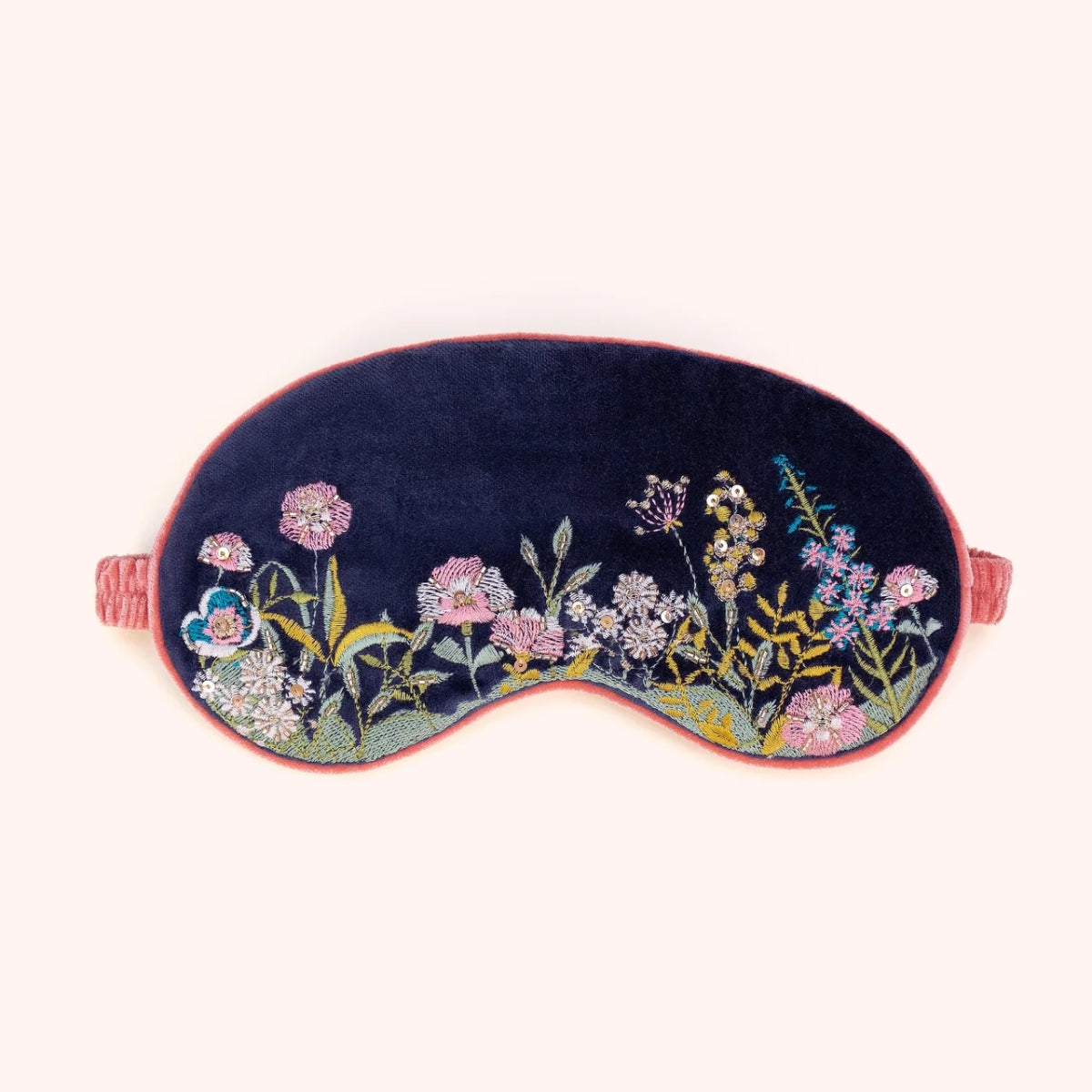 Navy velvet eye mask hand embroidered with a pink and gold floral hedgerow motif, coral piping and elastic strap