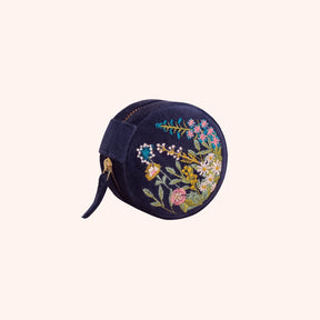 Navy velvet round jewelry box hand embroidered with a pink, gold, and blue floral hedgerow motif
