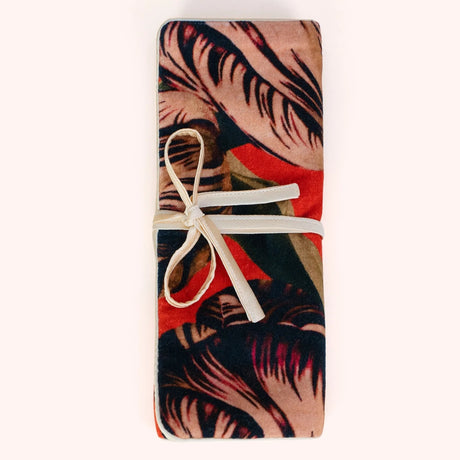 Coral and green tulip print velvet jewelry roll tied closed with a cream ribbon