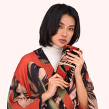 Model holding the coral tulip print jewelry roll against a matching printed kimono