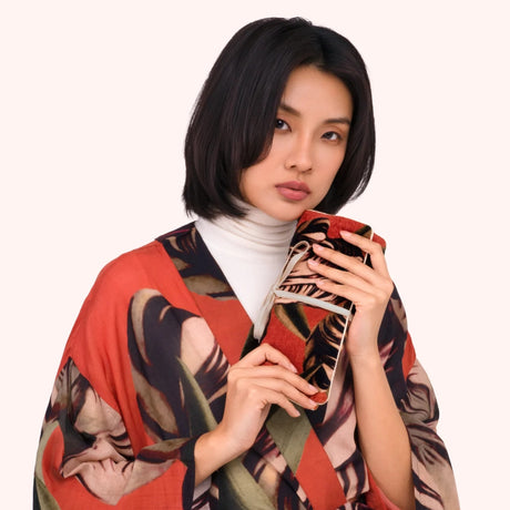 Model holding the coral tulip print jewelry roll against a matching printed kimono