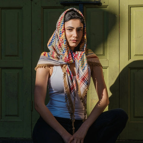 Model wearing SEP beige multicolor keffiyeh scarf styled as a headwrap with fringed edges falling over the shoulders