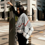 Front view of model wearing SEP black and white cotton keffiyeh scarf with red embroidery layered around the neck