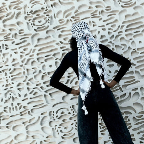 SEP folded black and white cotton keffiyeh scarf featuring hand-embroidered red Makateeb geometric border stitching and white tassels