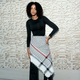 Close-up profile of model wearing SEP black and white keffiyeh scarf styled over the shoulders