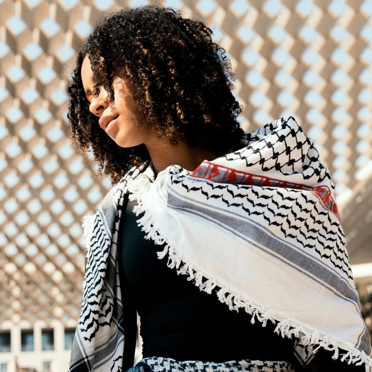 Model posing outdoors with SEP black and white cotton keffiyeh scarf draped softly across one shoulder
