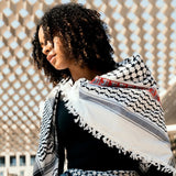 Model posing outdoors with SEP black and white cotton keffiyeh scarf draped softly across one shoulder