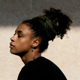 Side profile of model wearing SEP khaki green cotton keffiyeh scarf styled as an elegant headwrap