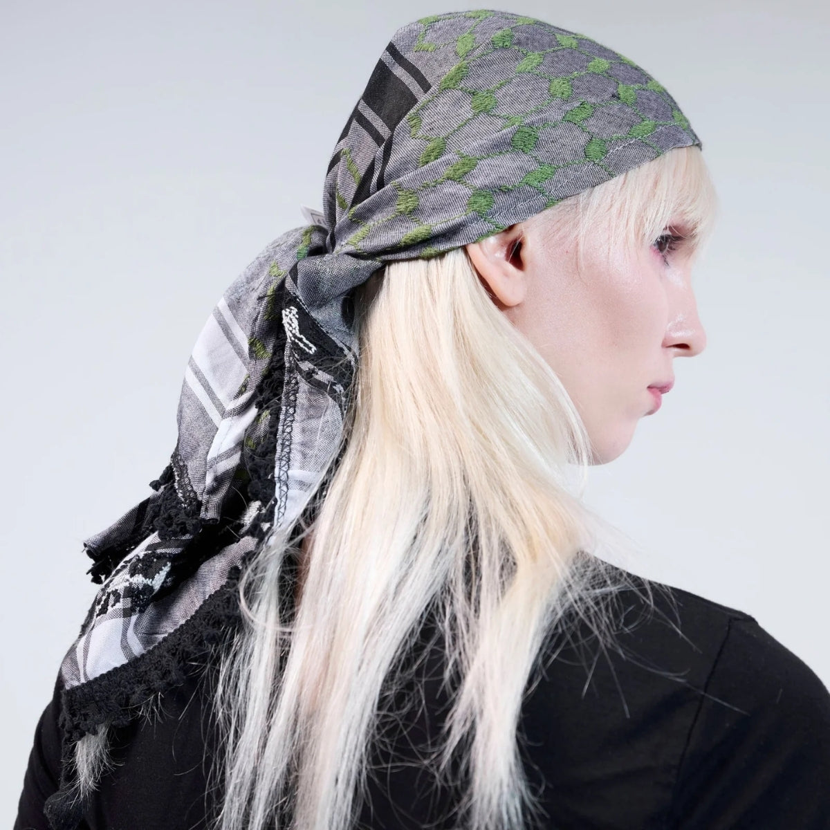 Side profile of blonde model wearing SEP mini green and grey keffiyeh scarf styled as a bandana headwrap