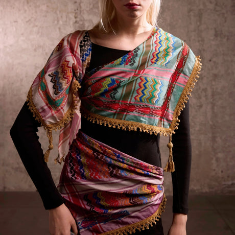 Model wearing SEP mini green multicolor keffiyeh draped across the upper body showing crocheted fringe and tassel trim
